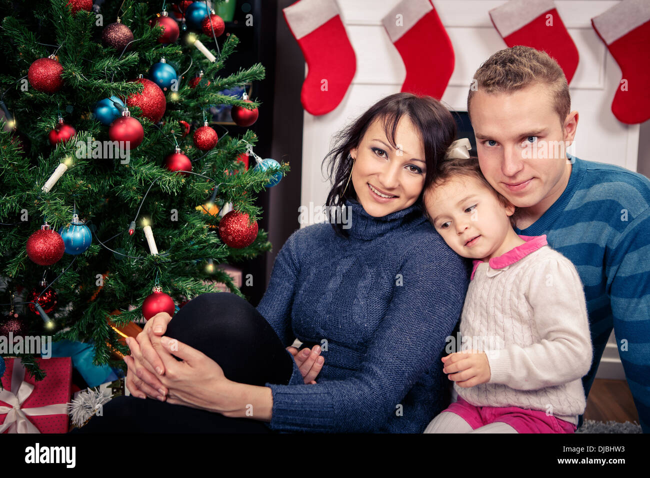 young family in front of christmas tree Stock Photo Alamy