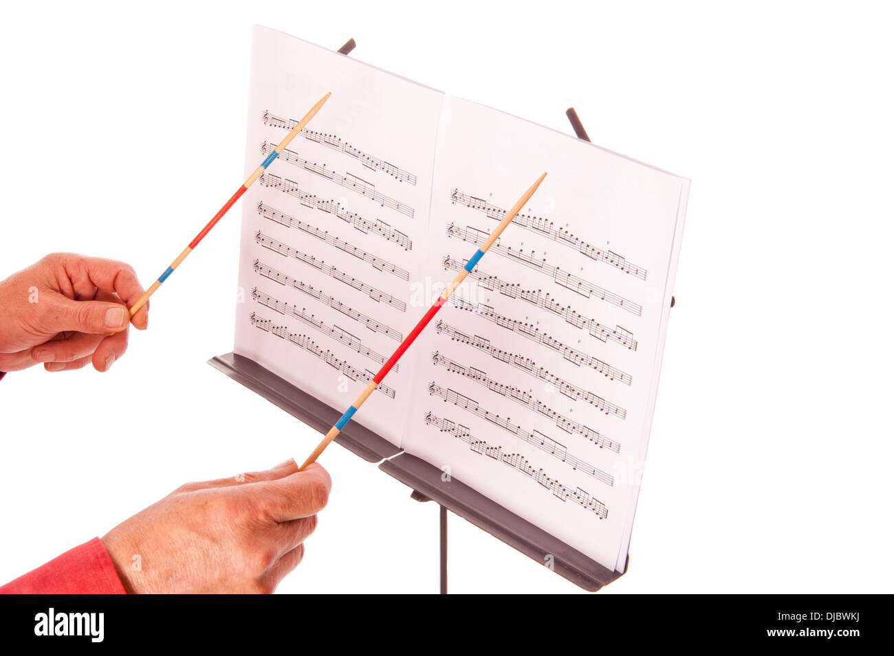 Conductor with baton directing melody from music sheet stand Stock Photo