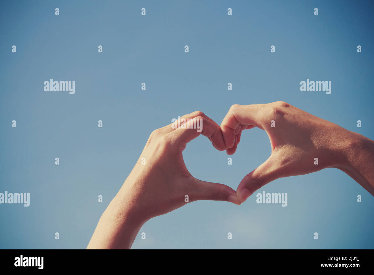 Girl hand in heart form love blue sky Stock Photo - Alamy