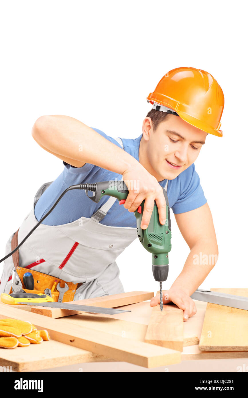 Manual worker drilling with a hand drilling machine in a workshop Stock Photo