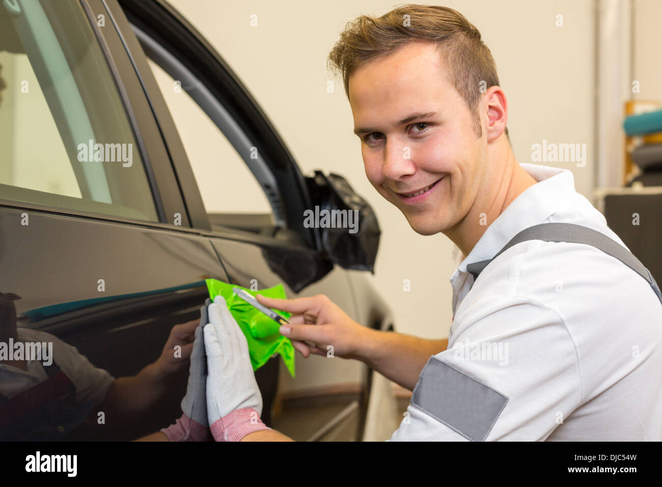 Car wrapping specialist cutting adhesive foil or film with a box cutter