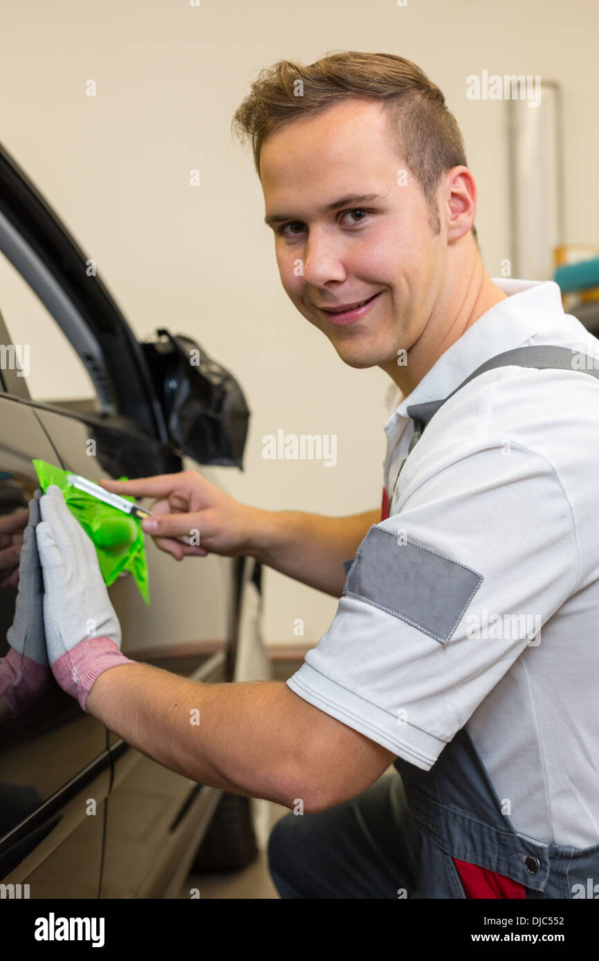 Car wrapping specialist cutting adhesive foil or film with a box cutter