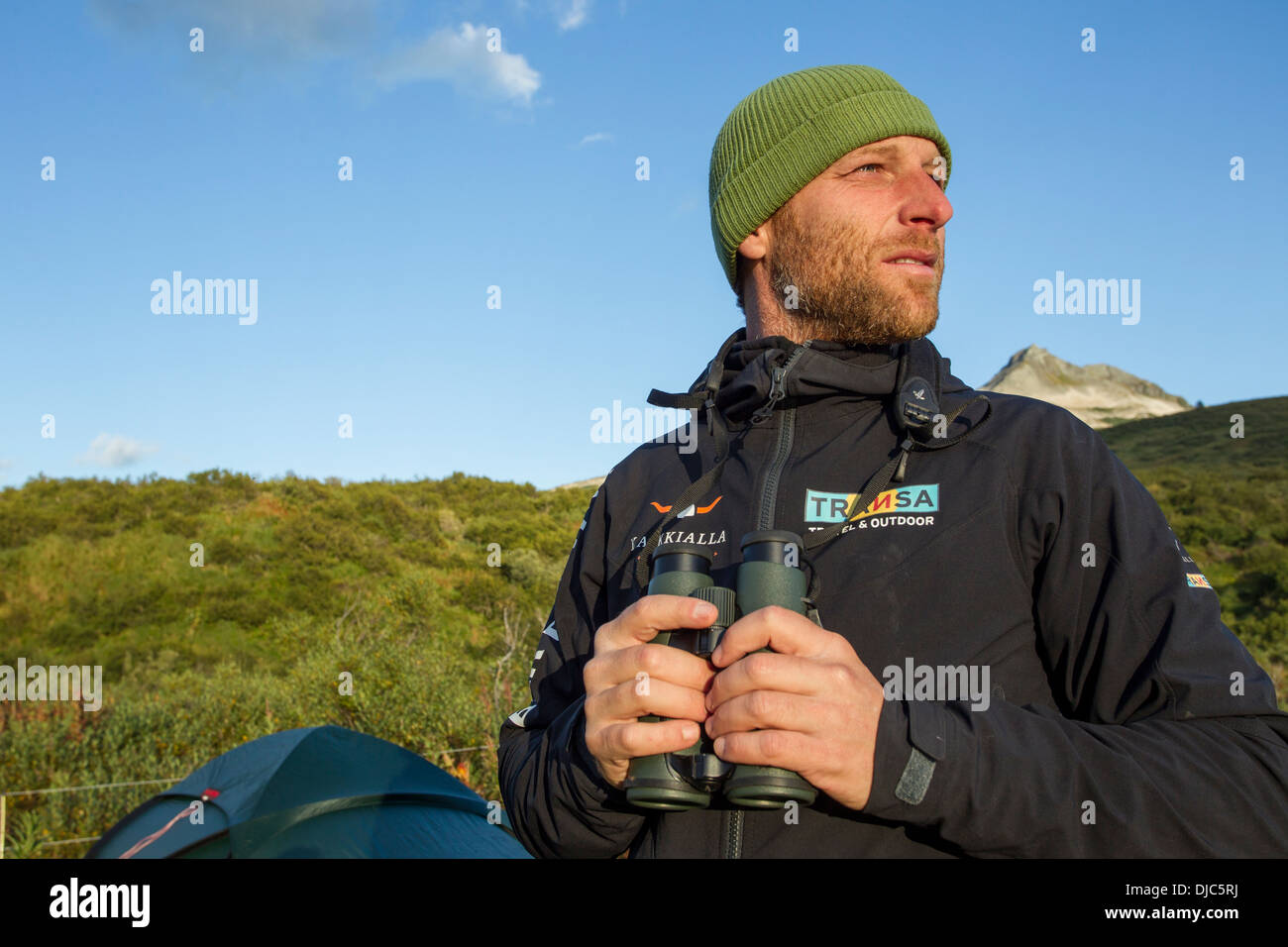 USA, Alaska, Katmai National Park, Swiss biologist and photographer David Bitter watches setting sun along Katmai Coast Stock Photo