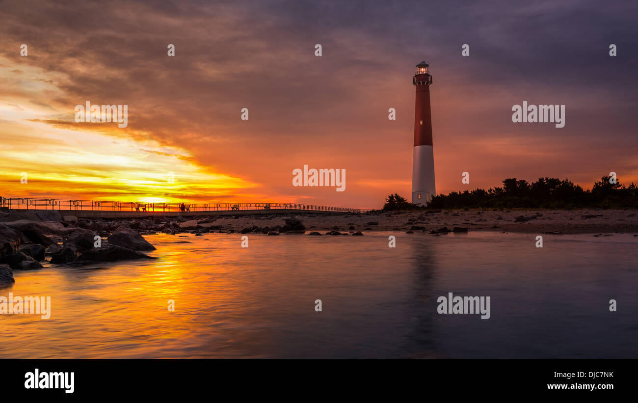 Barnegat Lighthouse at sunset.  Barnegat Lighhouse is a historic landmark located on the northern tip of Long Beach Island. Stock Photo
