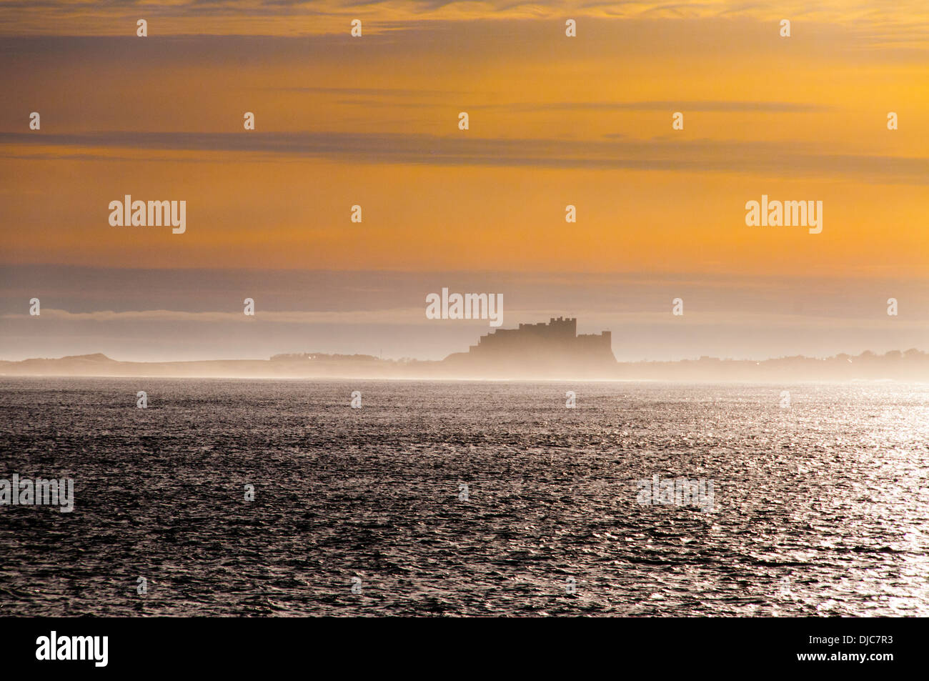 Sunrise over the Castle at Bamburgh from Holy Island Stock Photo