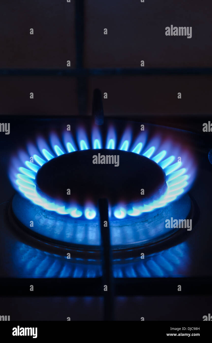 Burning blue flame of British Gas and rising fuel and energy prices costs expenses for cooking heating shareholders reap returns Stock Photo