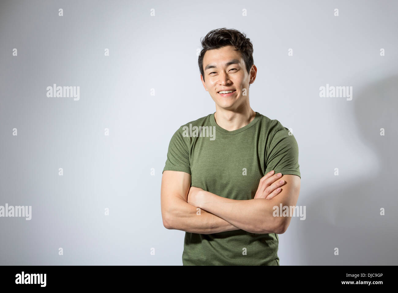 Athletic young male standing with arms folded Stock Photo