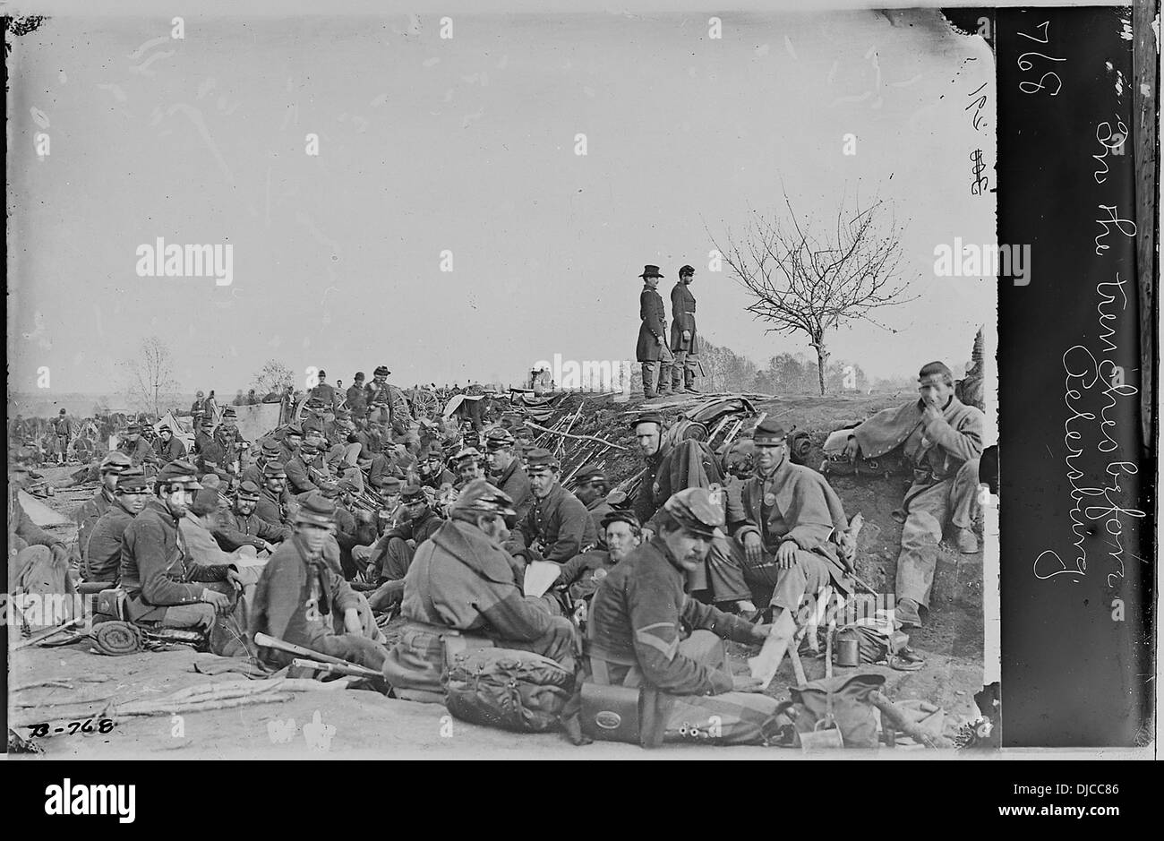 Soldiers are shown in the trenches during the Siege of Petersburg, Virginia, a pivotal battle in the American Civil War. The scene depicts soldiers engaged in their daily routines, taking cover, and preparing for combat in the difficult conditions of trench warfare. Stock Photo