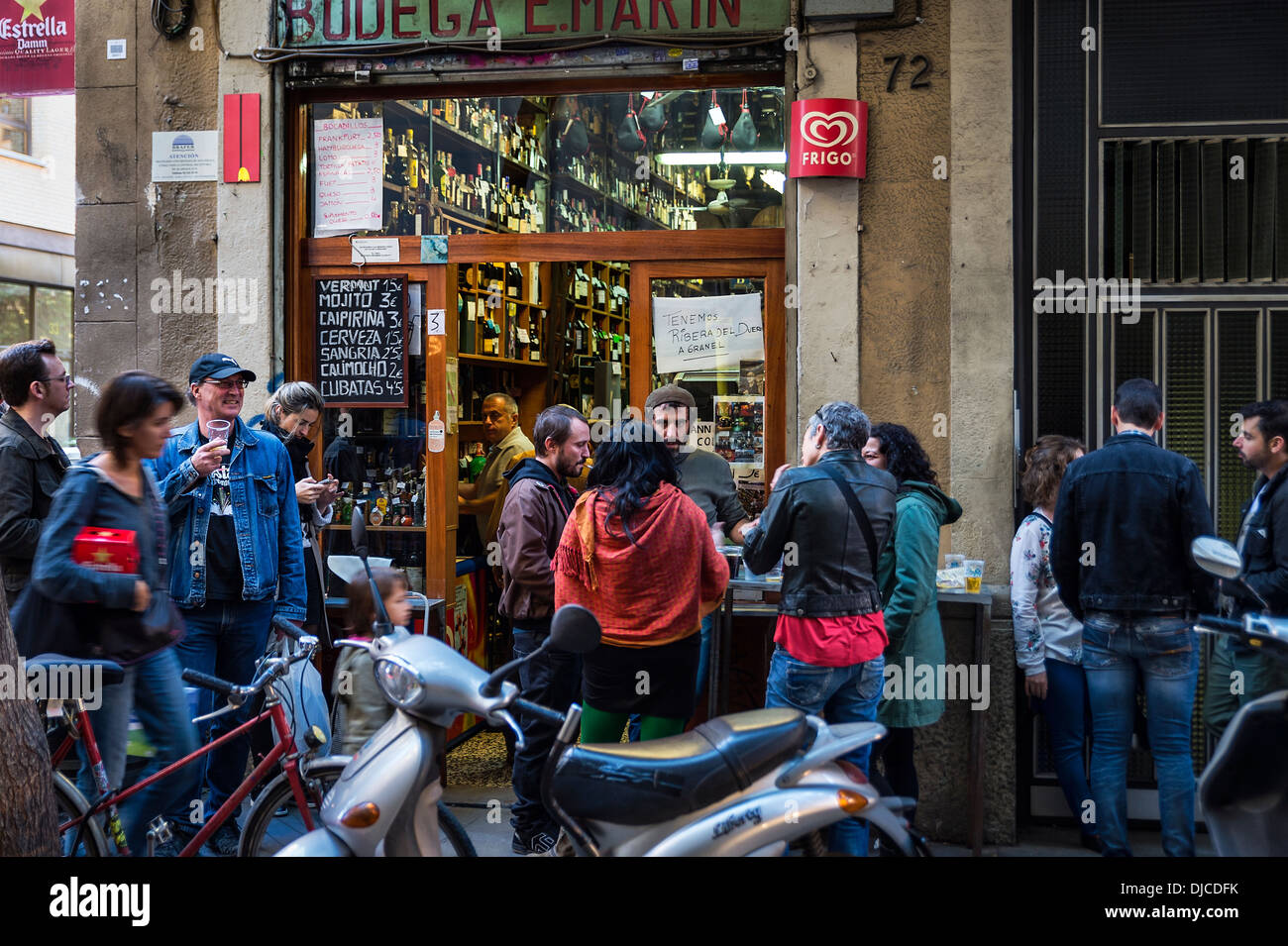Bodega patrons spill out into the street to socialize and consume wine and beer, Barcelona, Spain Stock Photo
