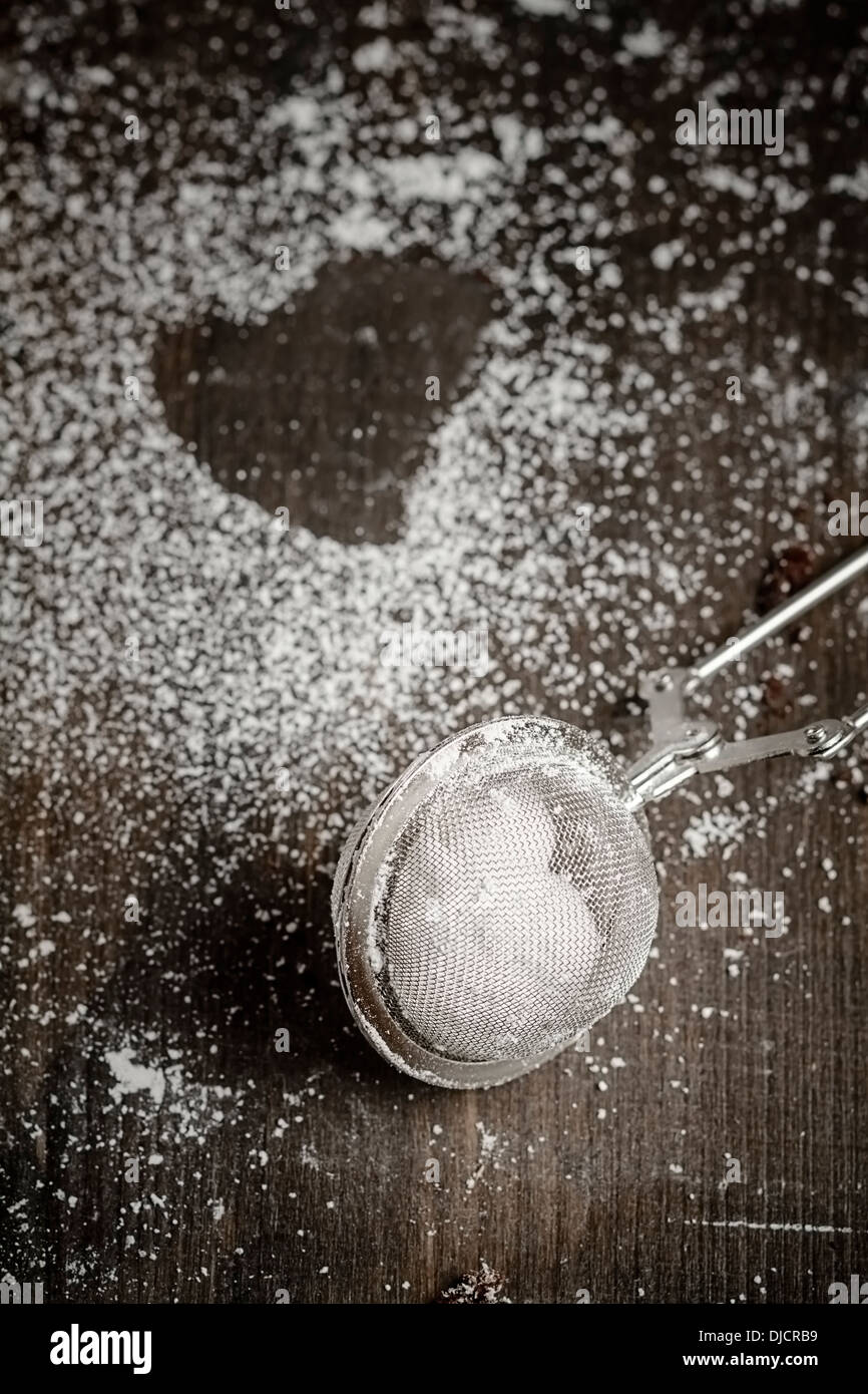 Tea strainer filled with icing sugar and imprint of cookie Stock Photo