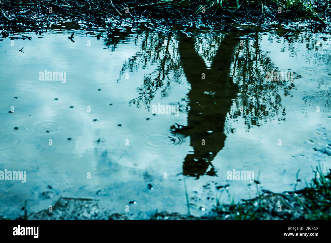 Reflection of a woman in a puddle Stock Photo