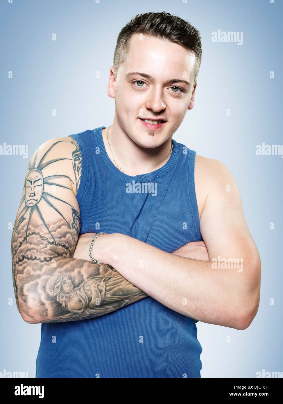 Portrait of a young man with tatoo on his right arm, studio shot Stock Photo