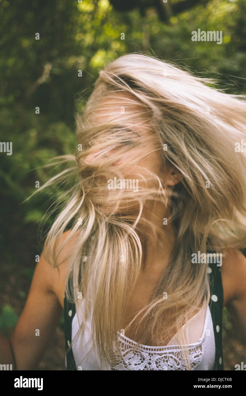 Happy blonde having her face covered by hair Stock Photo