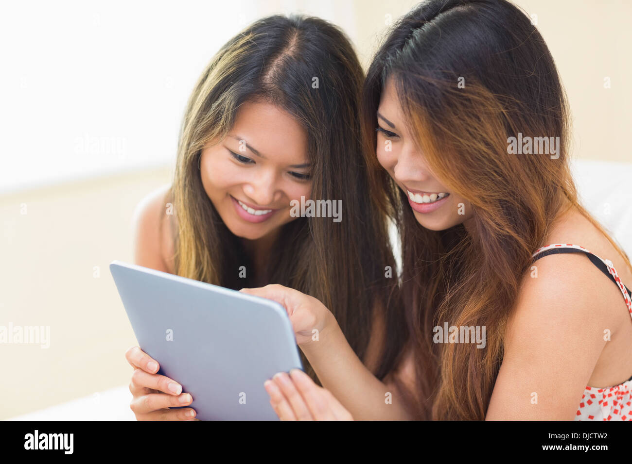 Two smiling brunette sisters using a digital tablet Stock Photo