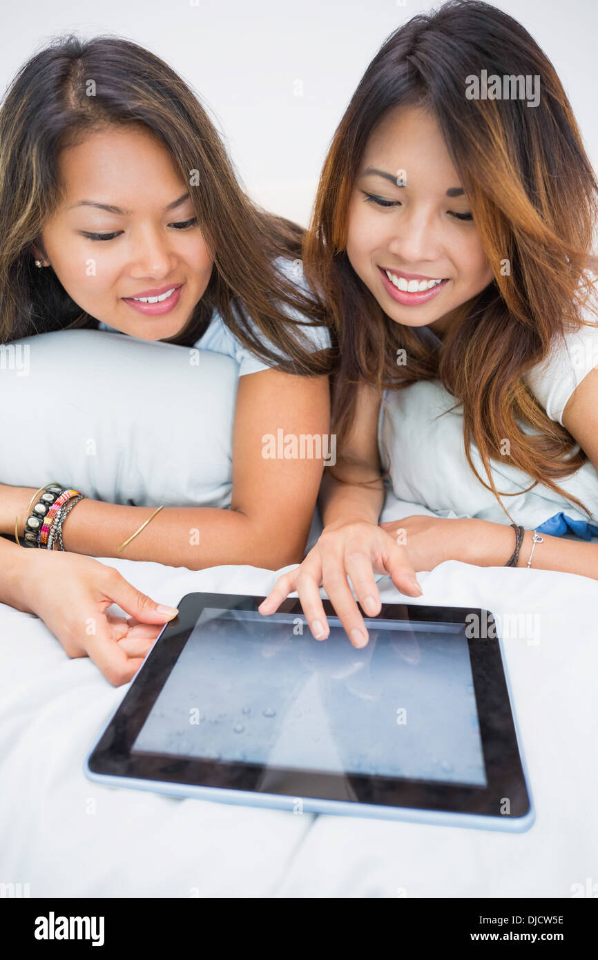 Two pretty sisters using a tablet Stock Photo