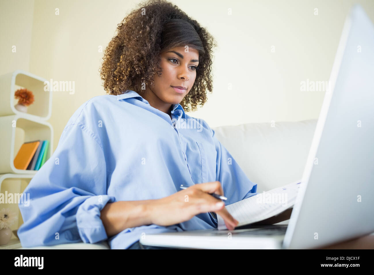 Pretty content student making notes and using laptop Stock Photo
