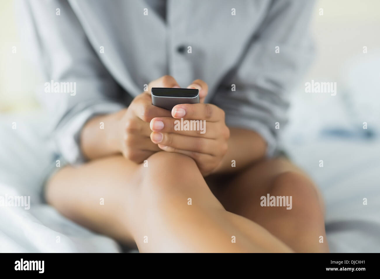 Mid section of pretty model holding mobile phone Stock Photo