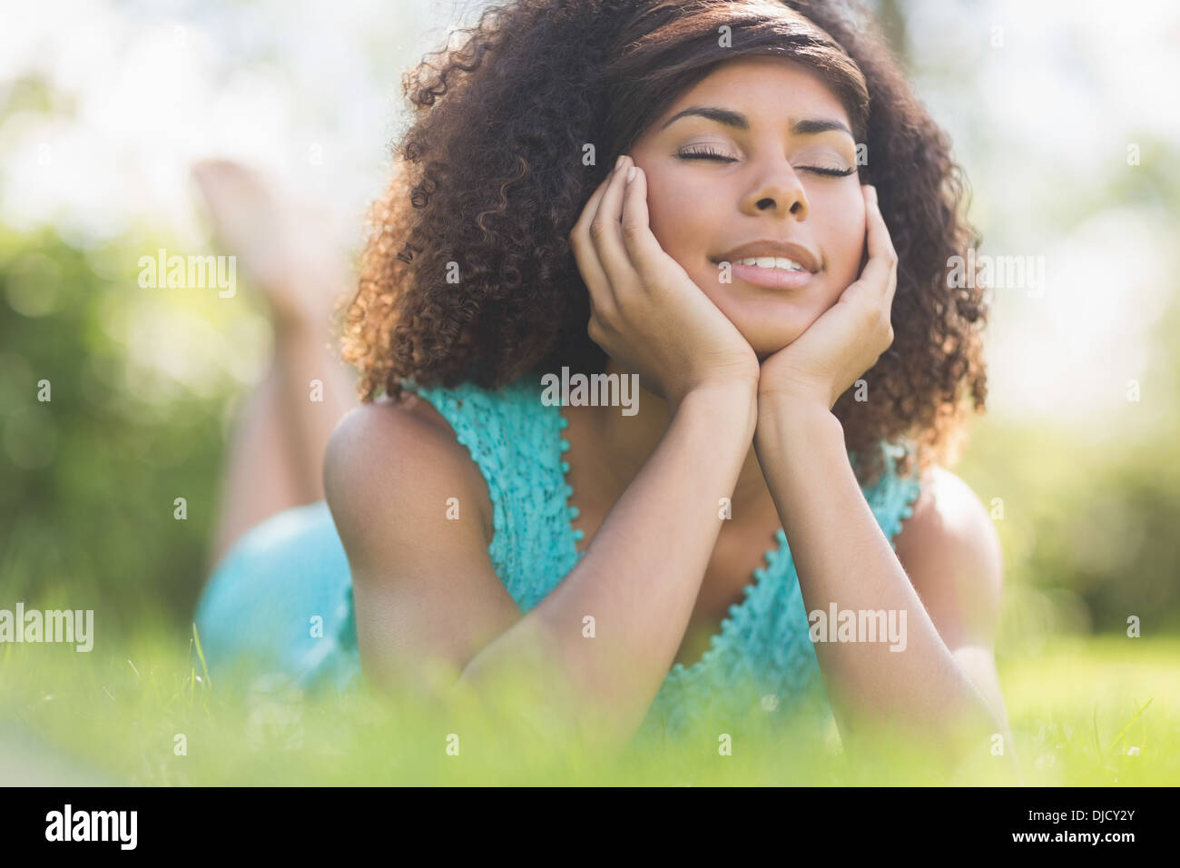 Gorgeous calm brunette lying on grass with closed eyes Stock Photo - Alamy
