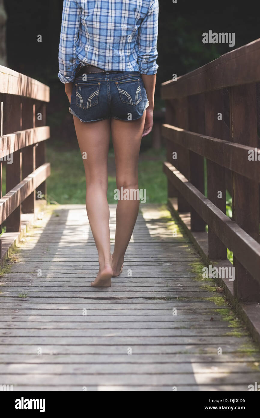 Backside of model walking on bridge Stock Photo