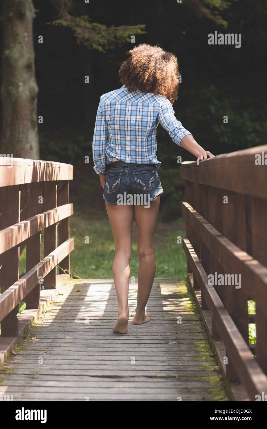 Rear view of gorgeous brunette walking on bridge Stock Photo - Alamy