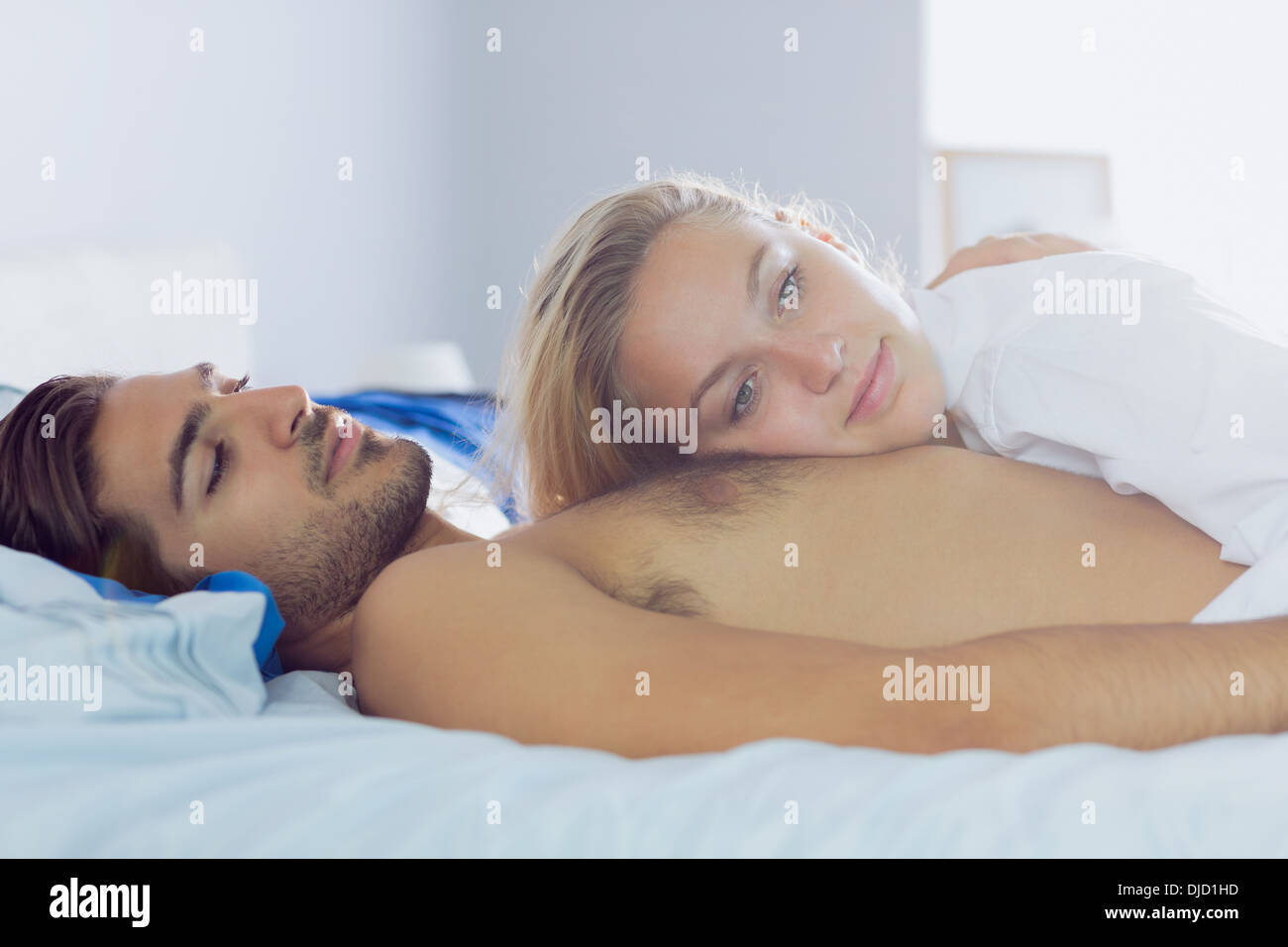 Smiling blonde woman lying on her boyfriend Stock Photo