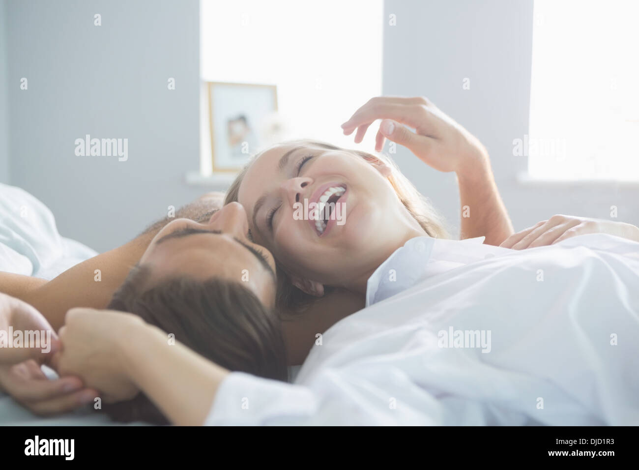 Content laughing couple lying on their bed Stock Photo