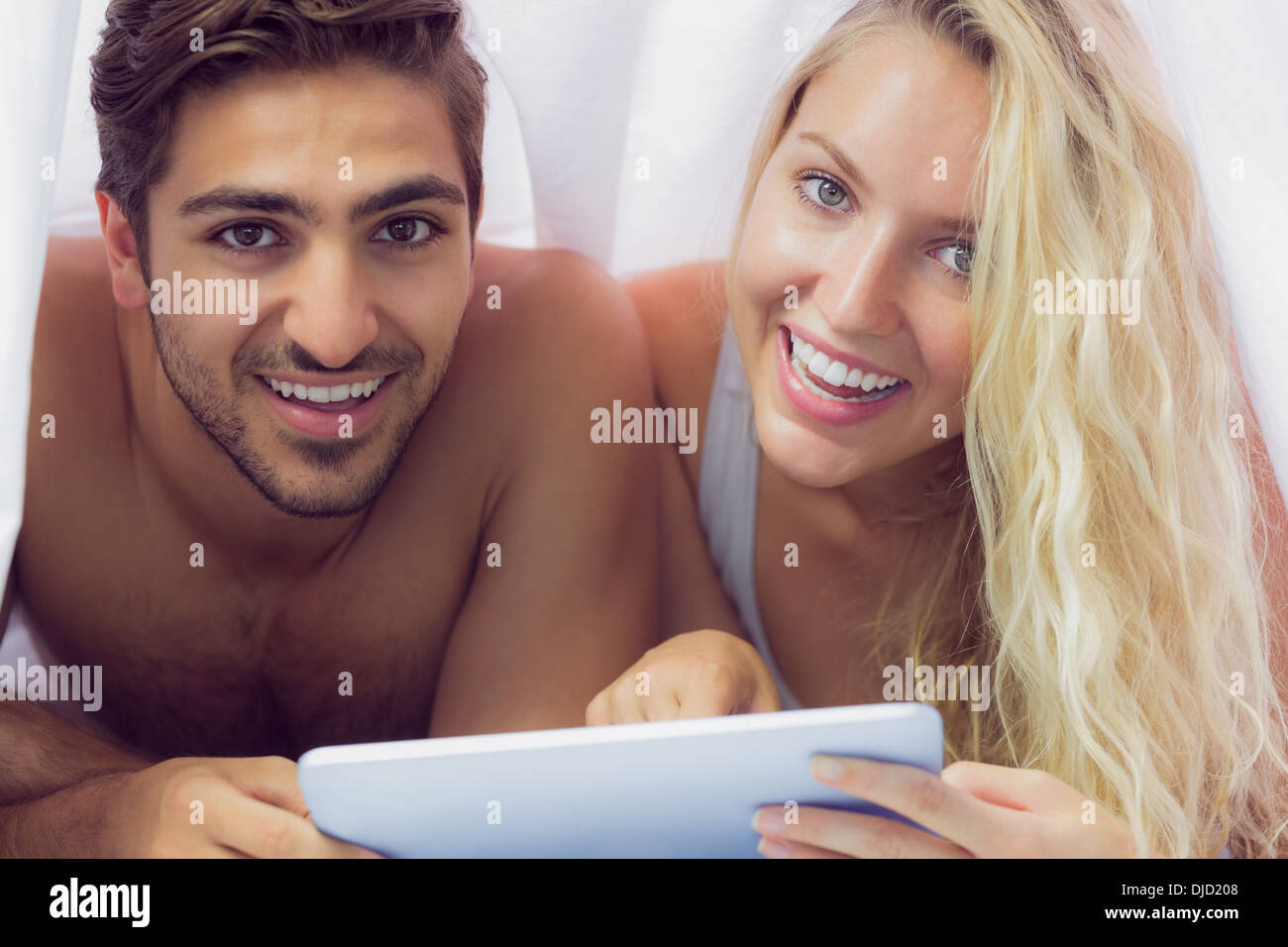Sweet couple lying under a blanket Stock Photo