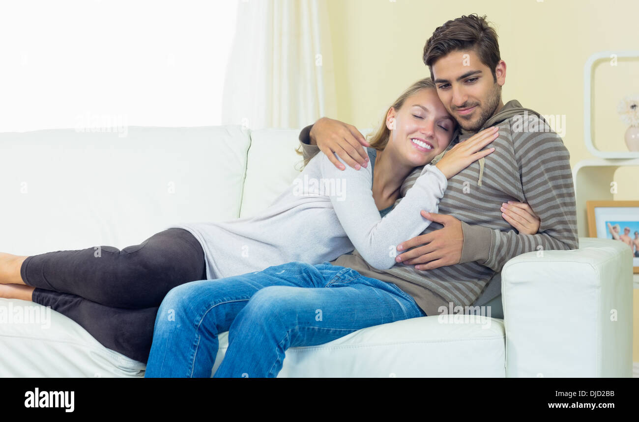Cute couple sitting on couch Stock Photo - Alamy