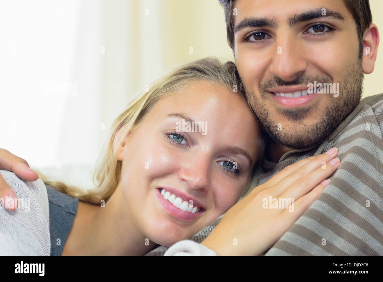 Nice young couple cuddling on couch Stock Photo