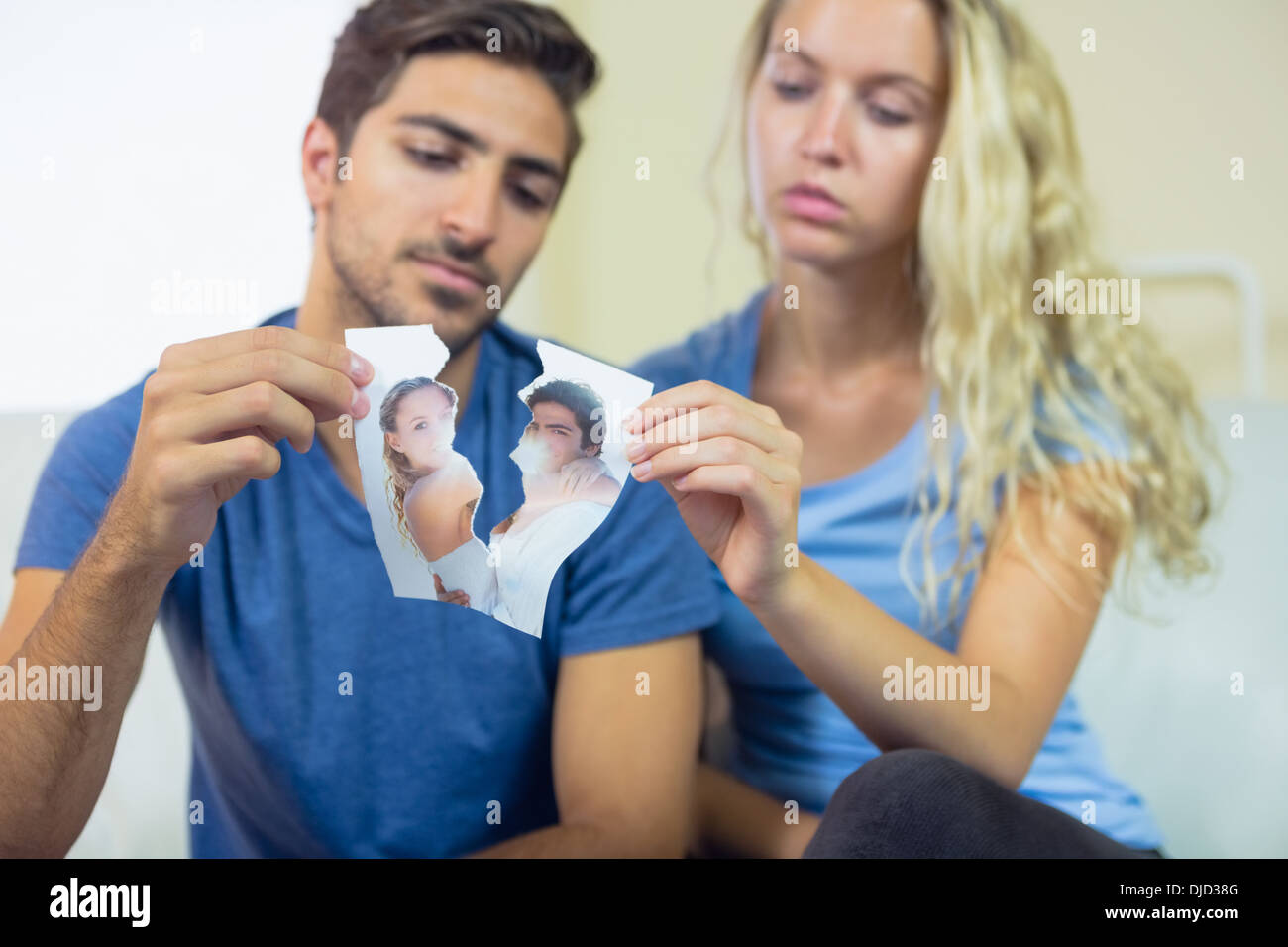 Young couple tearing a picture of them Stock Photo