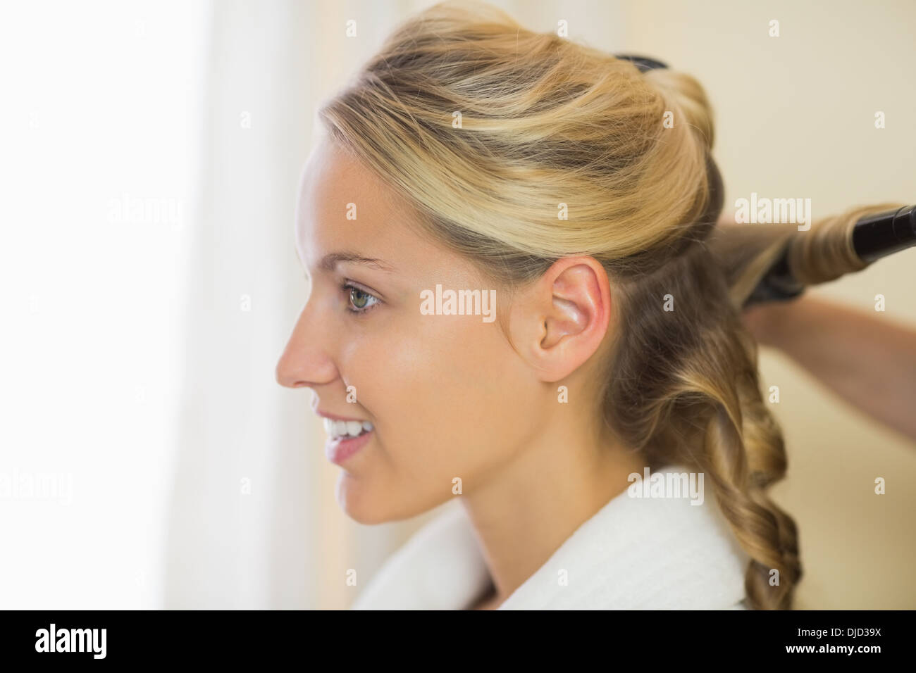 Blonde cute woman having her hair done Stock Photo