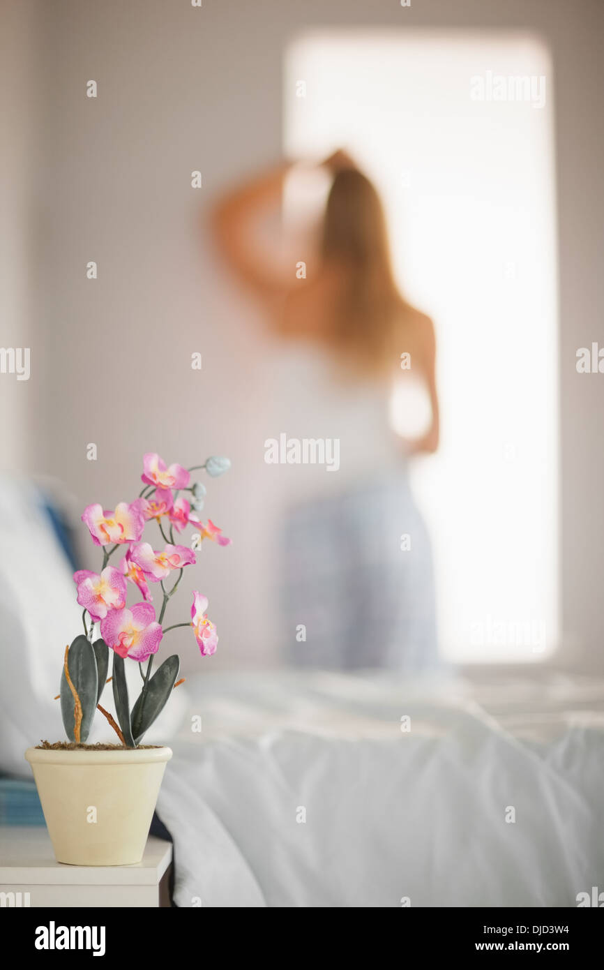 Focus on delicate pink flower in a pot on bedside table Stock Photo