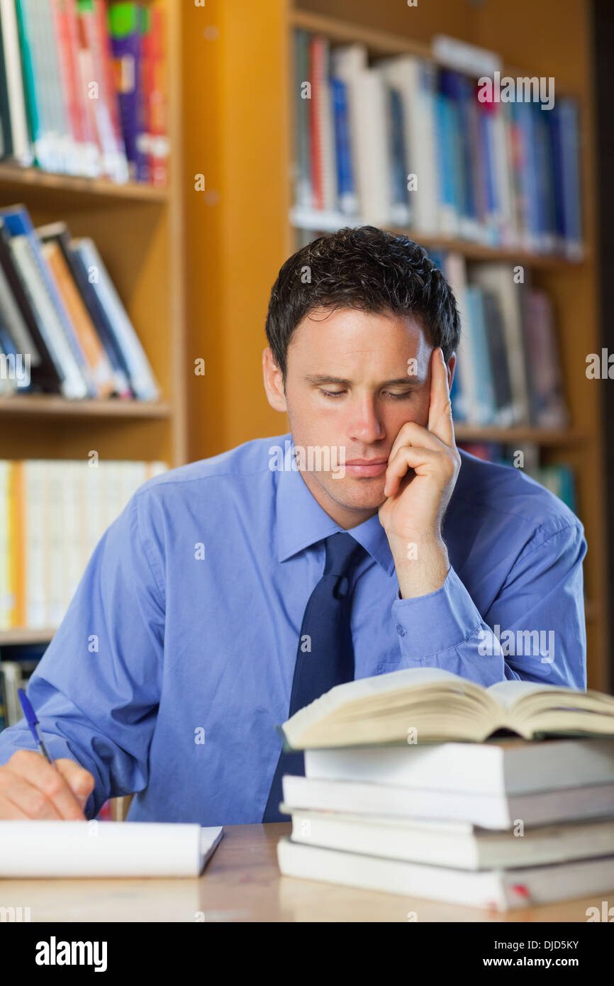 Focused librarian sitting at desk taking notes Stock Photo - Alamy