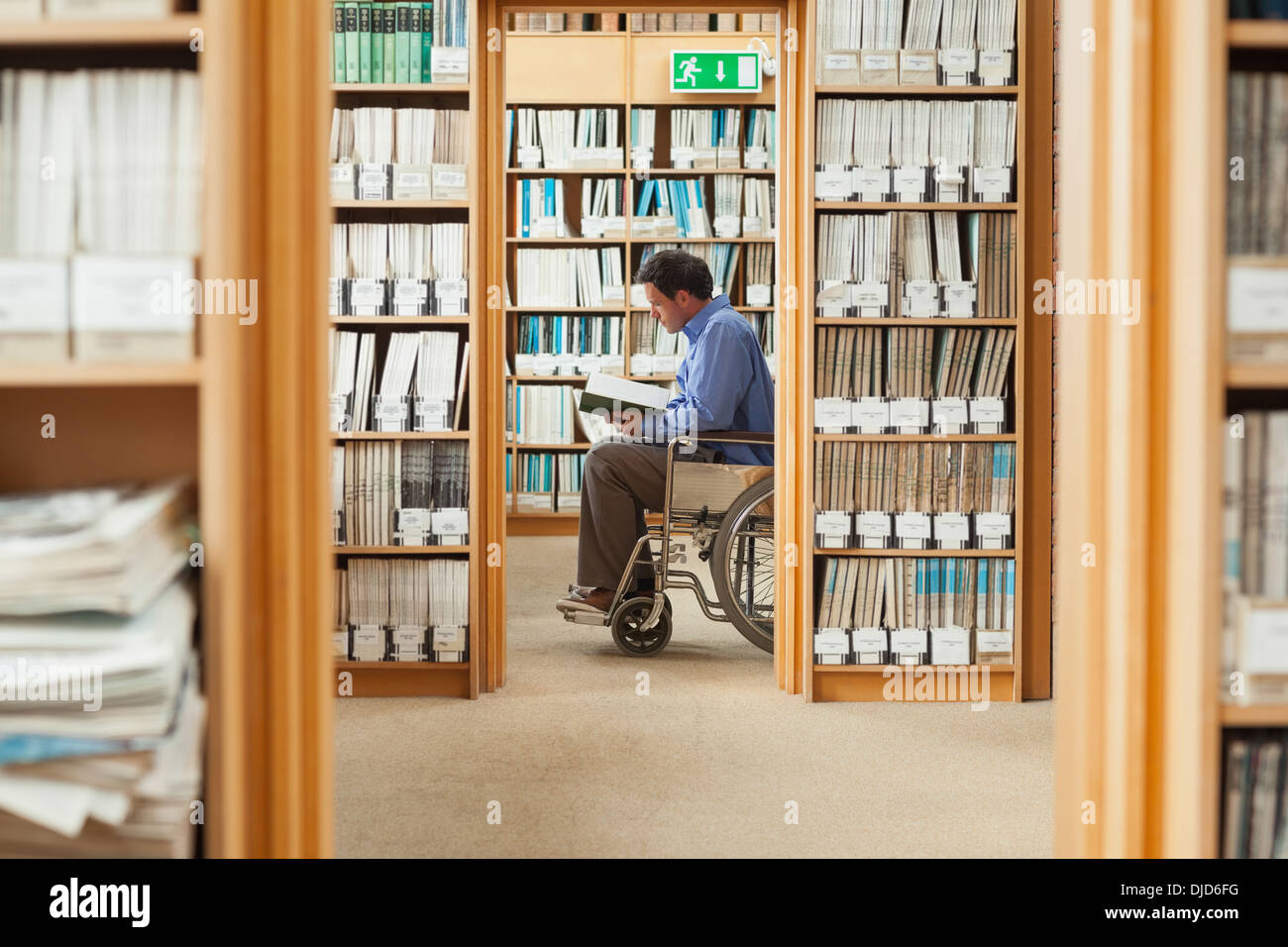 Man sitting in wheelchair reading a book Stock Photo