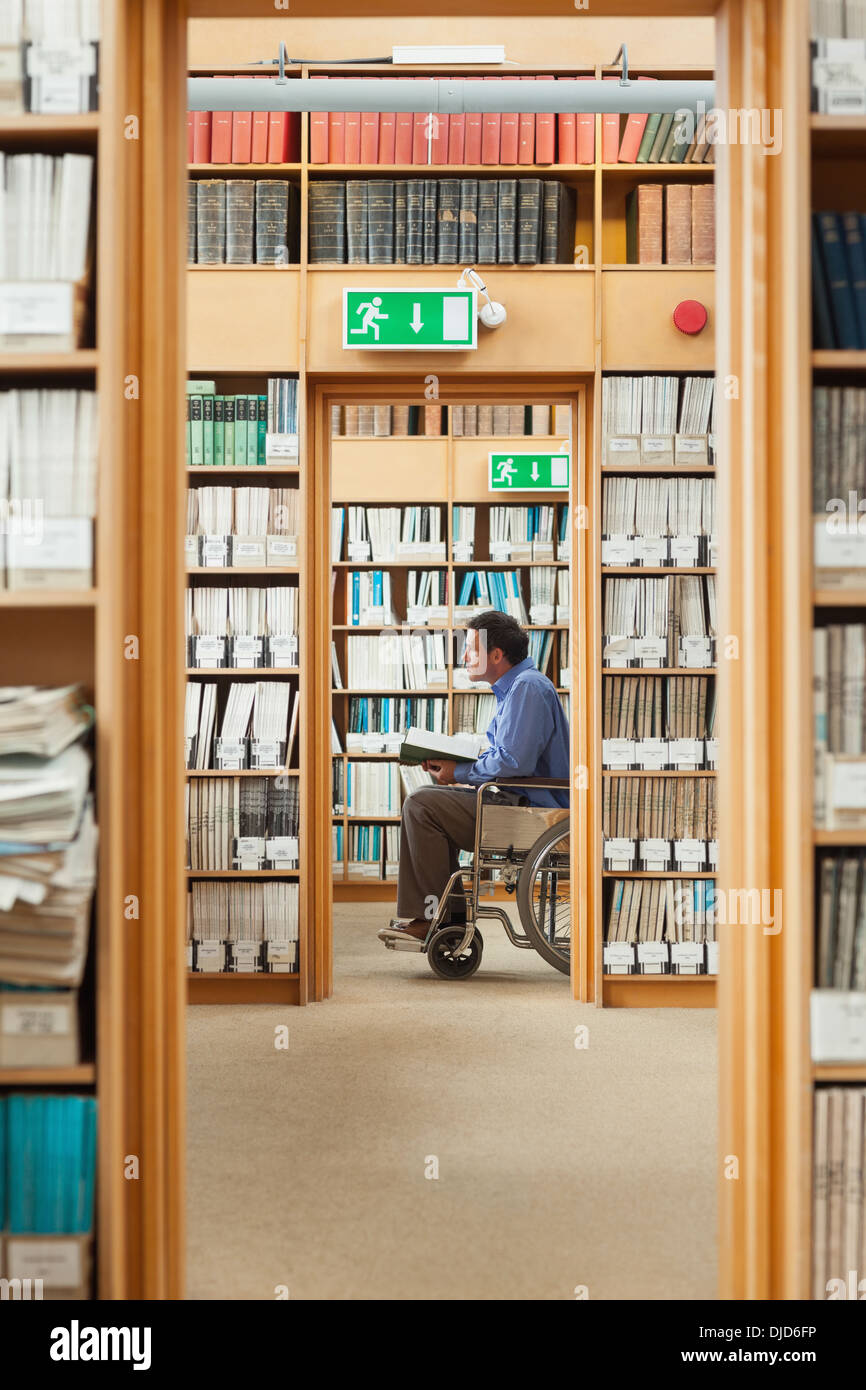 Man sitting in wheelchair holding a book Stock Photo