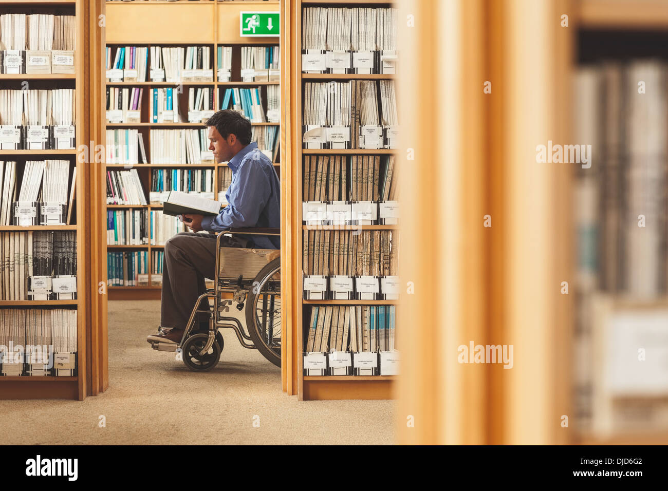 Man sitting in wheelchair looking at a book Stock Photo