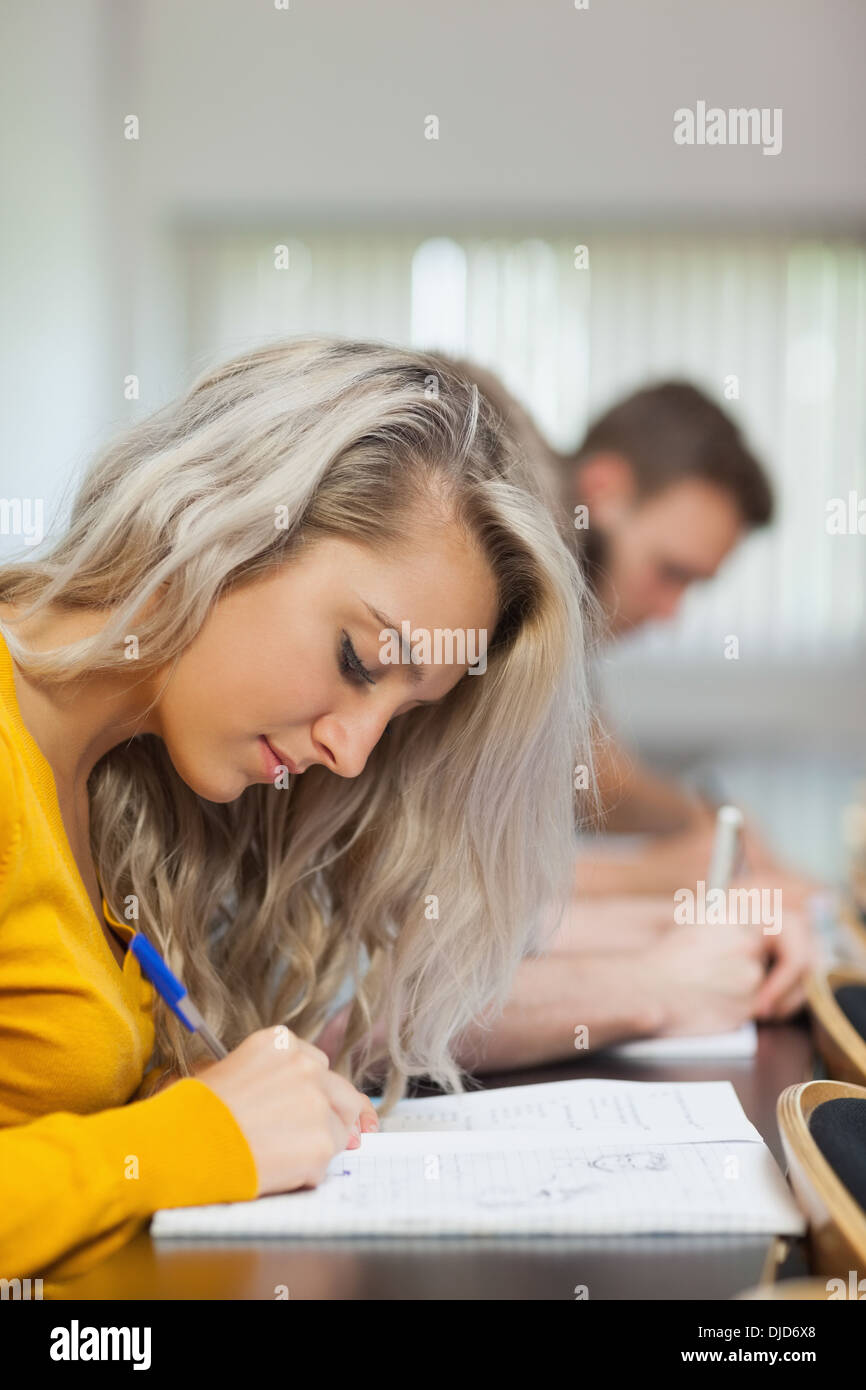 Blonde focused student taking notes Stock Photo