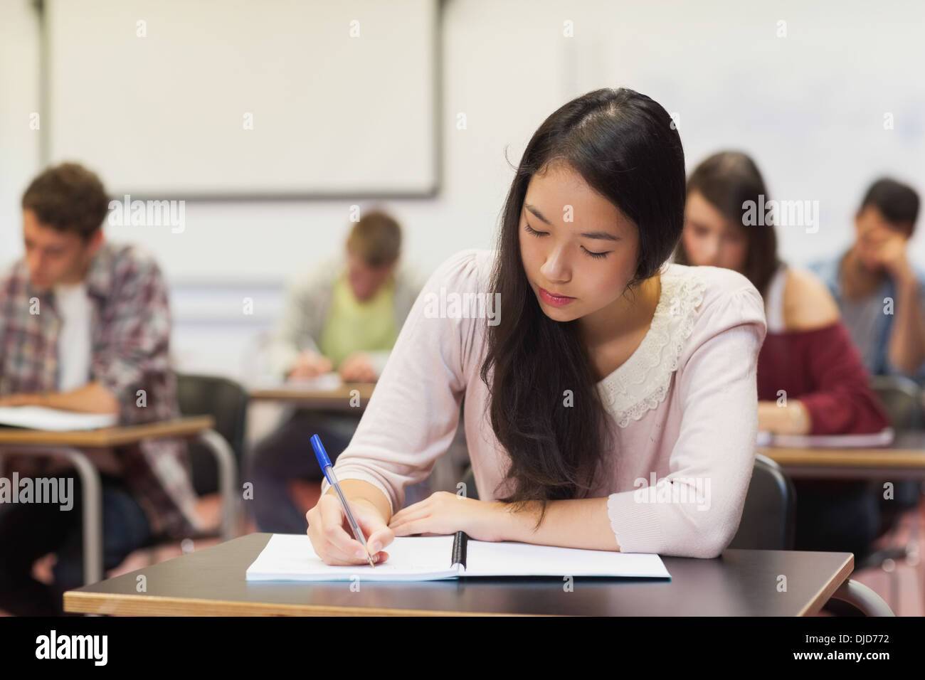 Focused asian student taking notes in class Stock Photo
