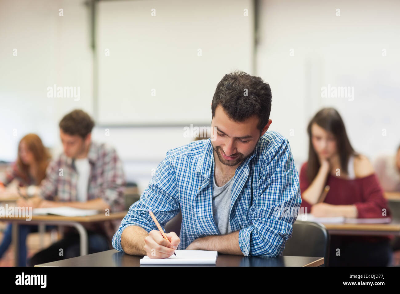 Focused student taking notes in class Stock Photo
