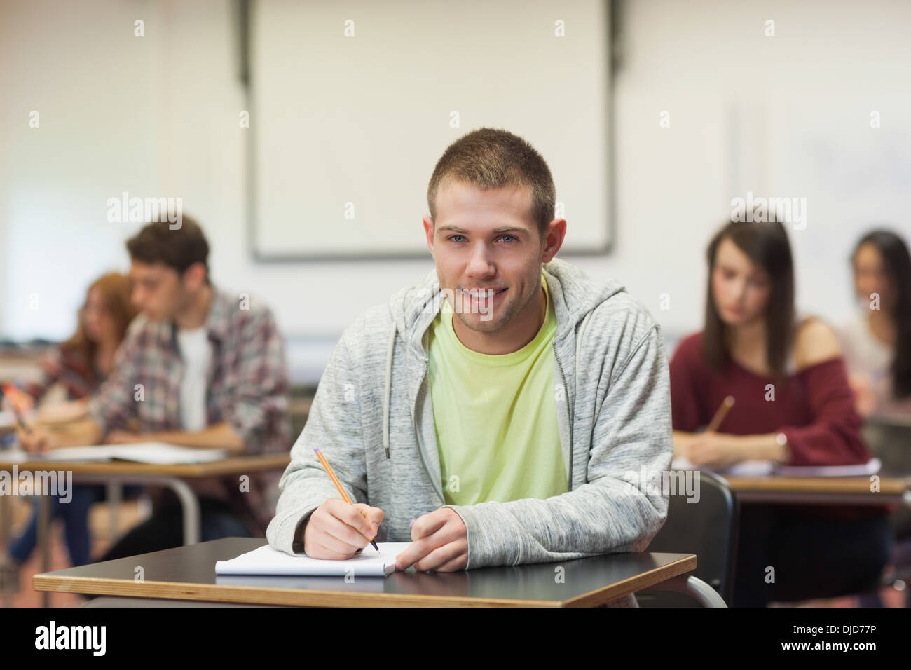 Focused happy student taking notes in class Stock Photo