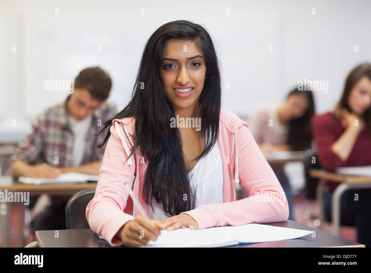Happy indian student taking notes in class Stock Photo