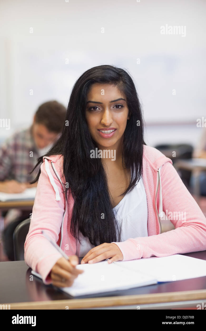 Smiling indian student listening in class looking at camera Stock Photo