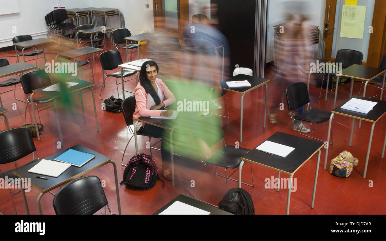 Students rushing in class with one girl smiling up at camera Stock Photo