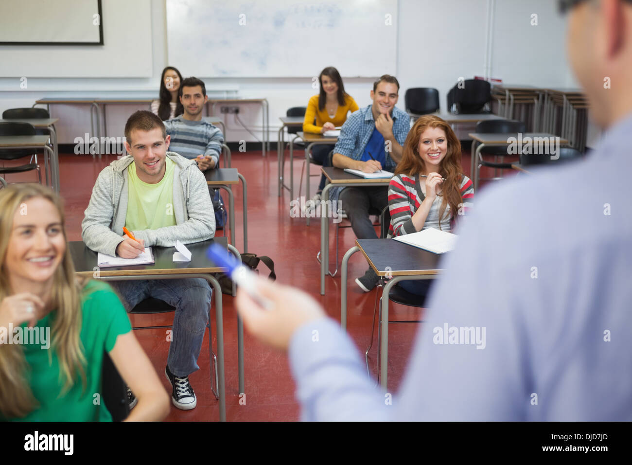 Students listening happily to their lecturer in class Stock Photo