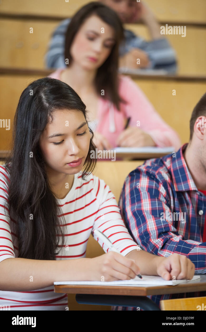 Focused asian student taking notes in lecture Stock Photo