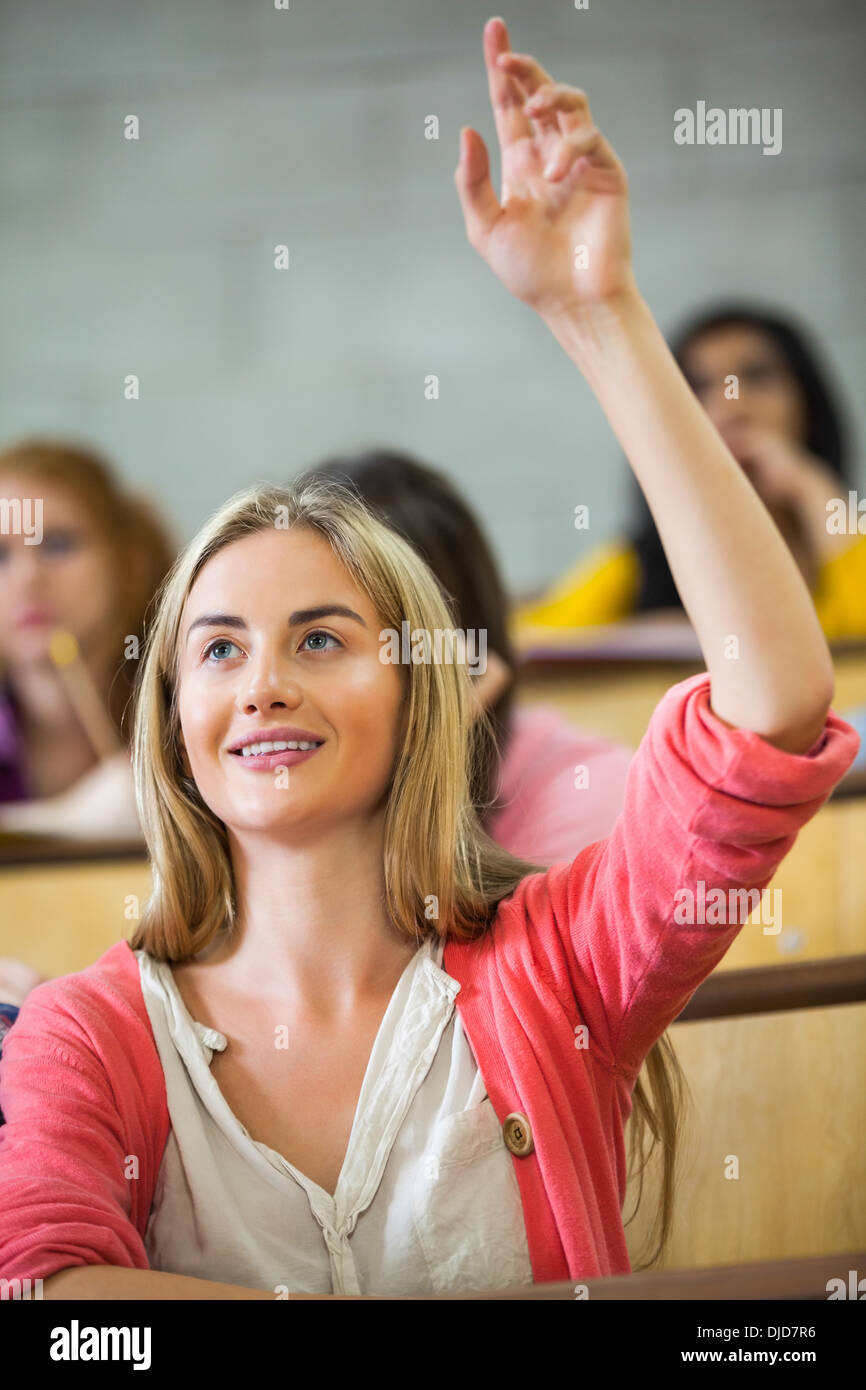 Happy student raising her hand in lecture Stock Photo
