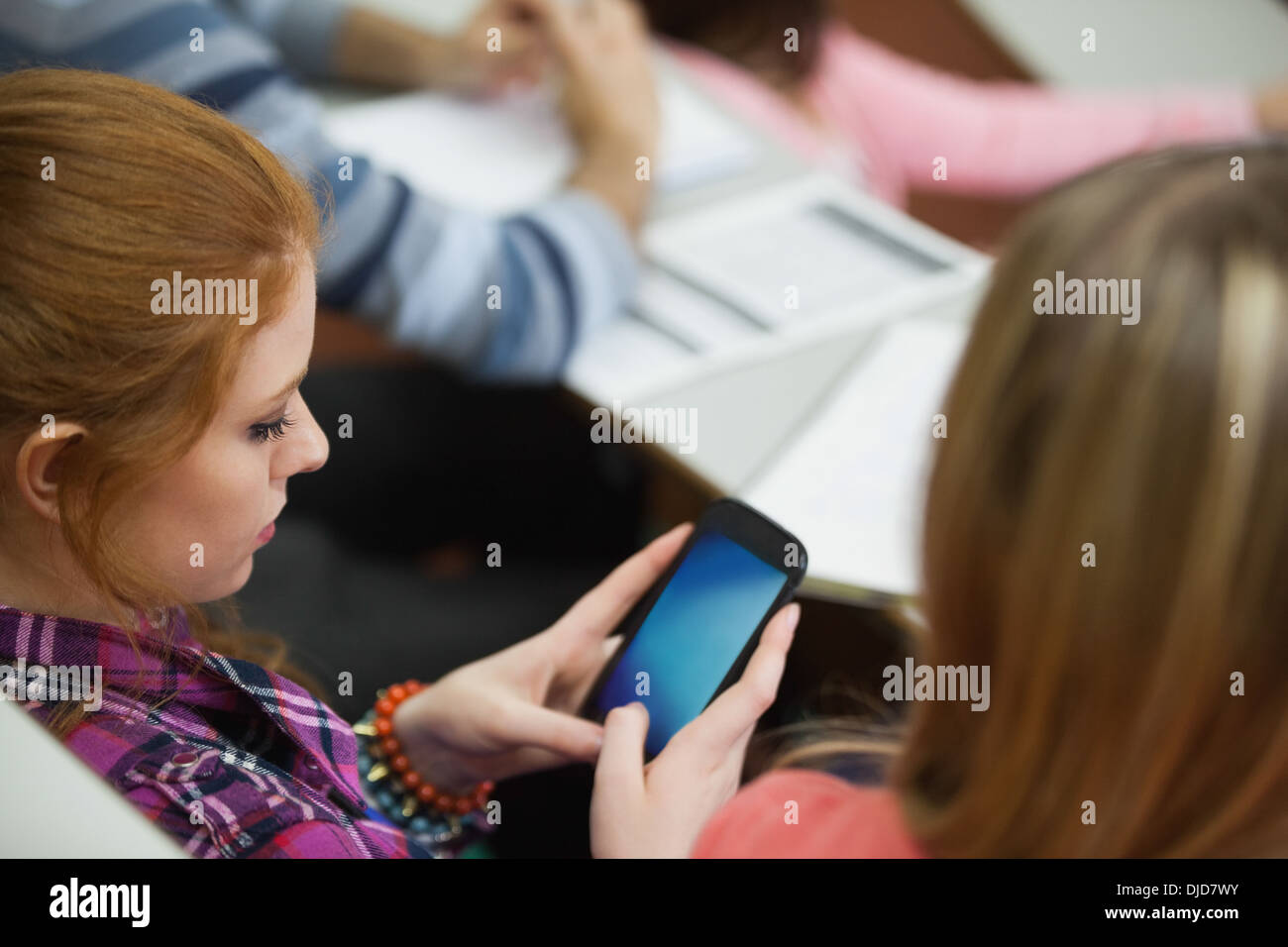 Student sitting in a lecture hall texting on her smartphone Stock Photo ...