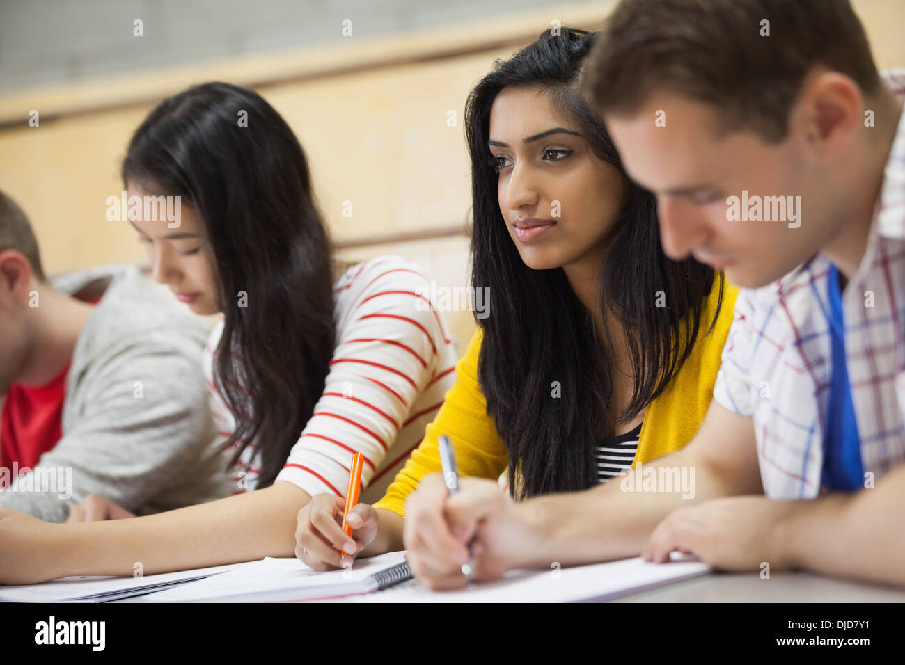 Row of happy students listening in a lecture hall Stock Photo
