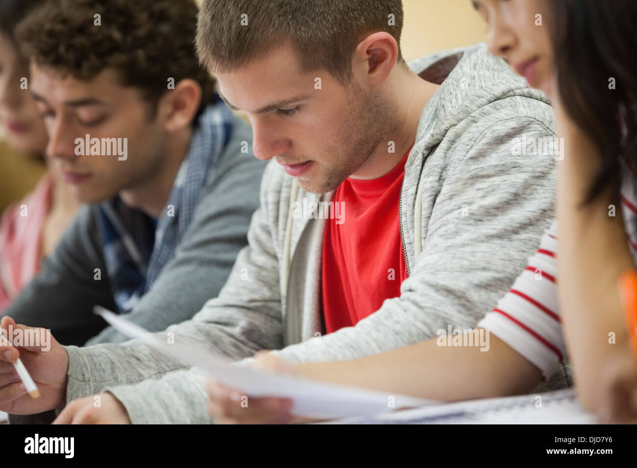 Row of students taking notes in a lecture hall Stock Photo