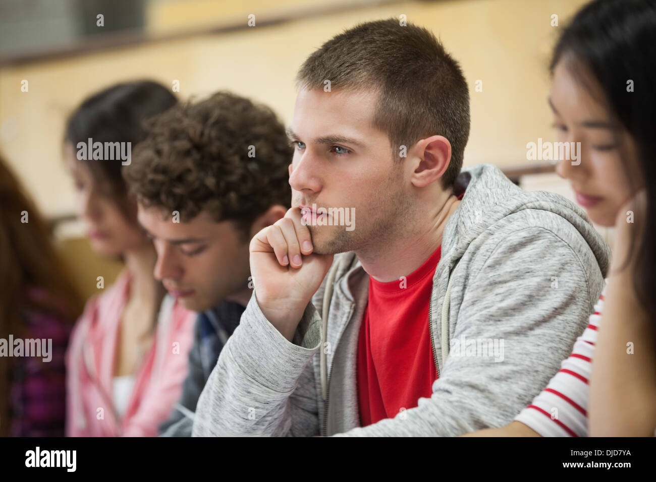 Row of concentrating students taking notes in a lecture hall Stock Photo